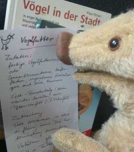 Wilma Wusel liest konzentriert ein handgeschriebenes Rezept für Vogelfutter.